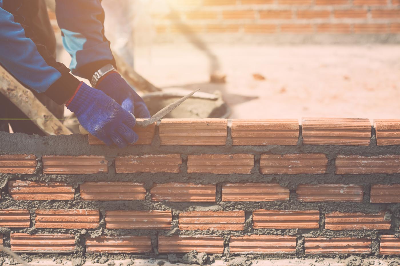 Worker installing bricks wall in process of house building